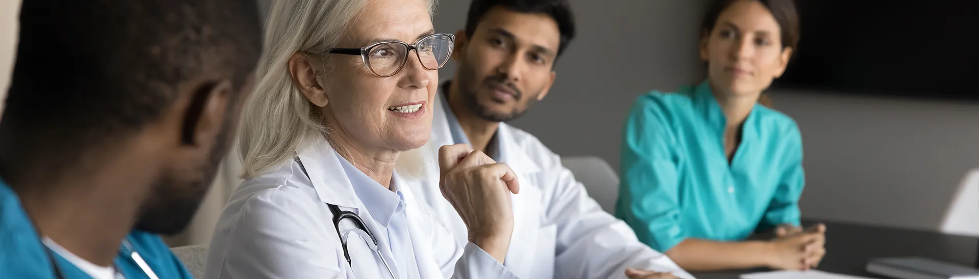 A group of medical providers sitting together discussing a topic.